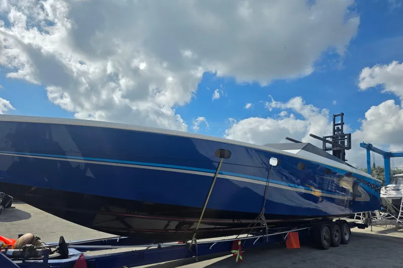 Slide: The Image of 2025 Don Smith Custom 55' boat on trailer under a cloudy sky. - 6