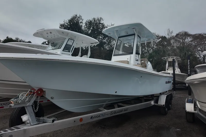 The Image of 2026 Blazer Bay 2440 boat on trailer, parked outdoors in a marina setting. - 0