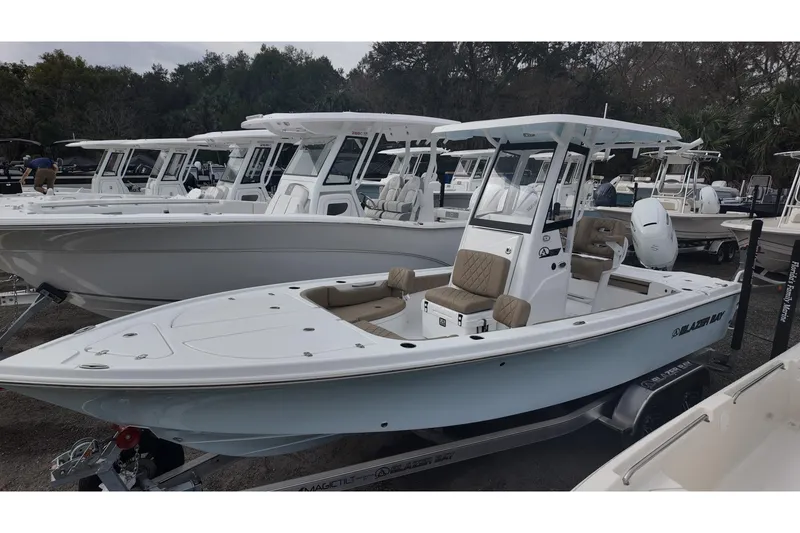 Slide: The Image of 2026 Blazer Bay 2440 boat on trailer, displayed outdoors with other boats. - 1