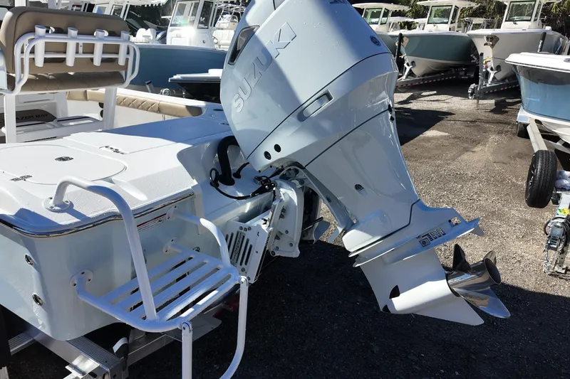 Slide: The Image of 2026 Blazer Bay 2440 boat with Suzuki outboard motor in a marina setting. - 19