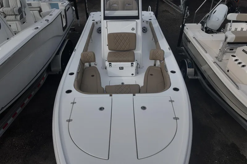 Slide: The Image of 2026 Blazer Bay 2440 boat on trailer, parked outdoors under clear blue sky. - 2