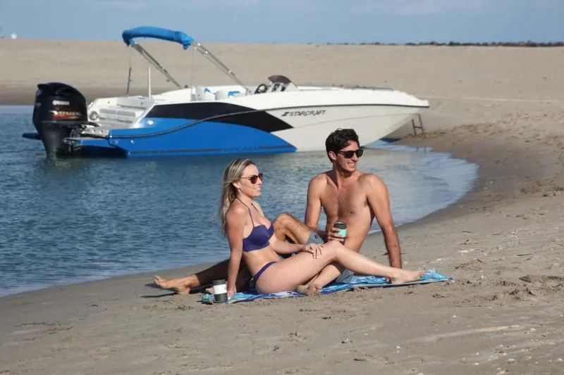Slide: The Image of Couple relaxing on beach near 2024 Starcraft 231 SVX boat. - 3