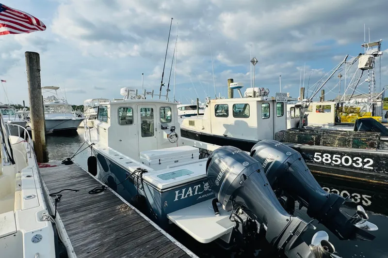 Slide: The Image of 2023 Parker 2520 XLD Sport Cabin boat docked with twin Yamaha engines. - 4