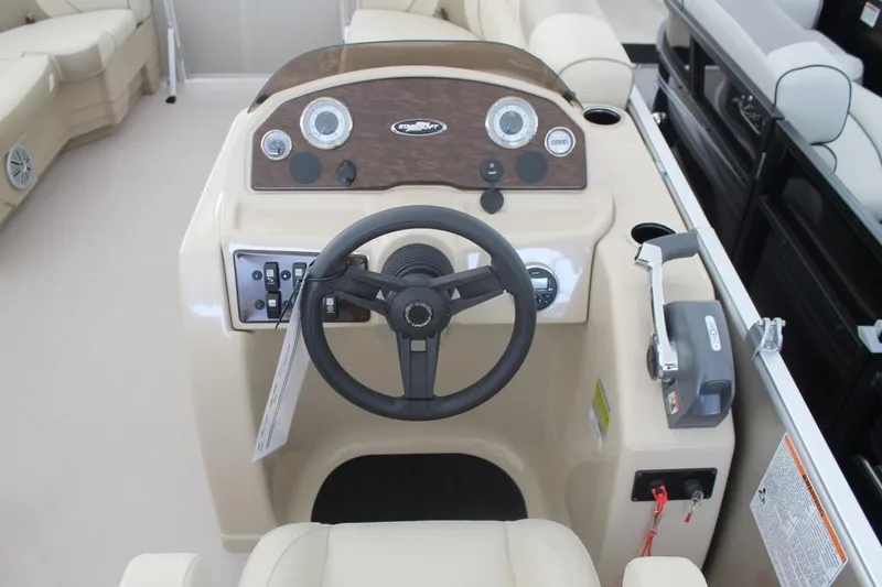 Slide: The Image of 2023 Starcraft EX 18 boat dashboard with steering wheel and control panel. - 13