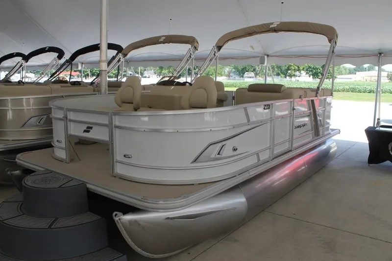 Slide: The Image of 2023 Starcraft EX 18 pontoon boat displayed under a canopy. - 2