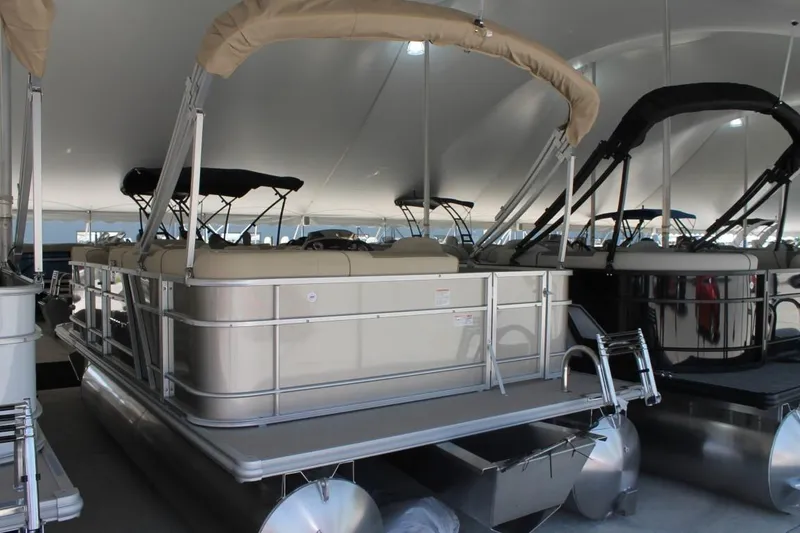 Slide: The Image of 2023 Starcraft EX 18 pontoon boat with beige canopy in showroom. - 3