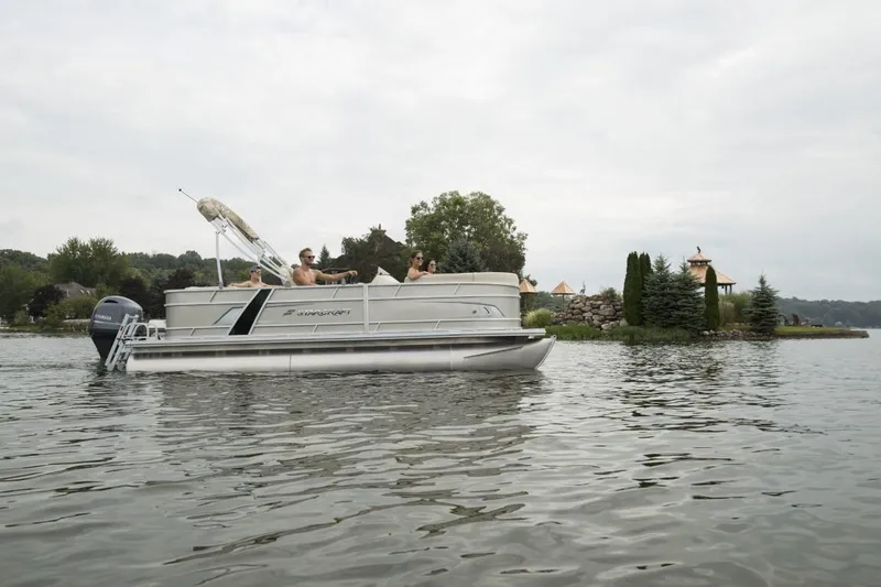 Slide: The Image of 2024 Starcraft EX 20 pontoon boat cruising on a lake with passengers. - 4