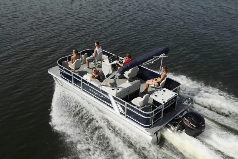 Slide: The Image of 2023 Starcraft EX 22 pontoon boat cruising with passengers on a lake. - 5