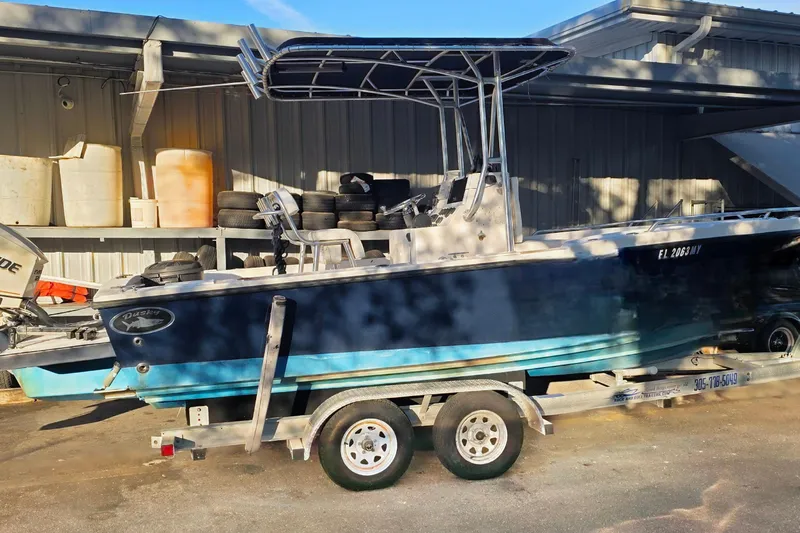 Slide: The Image of 2005 Dusky 203 boat on trailer, parked near a storage facility. - 1