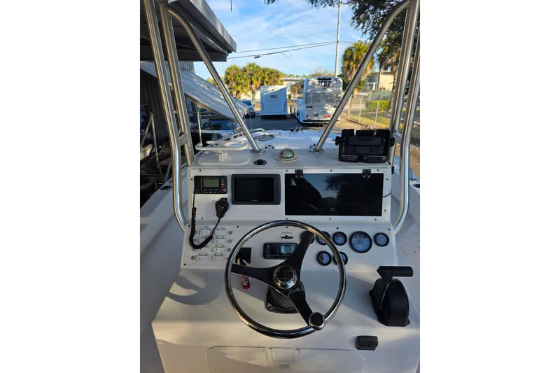 Slide: The Image of Dashboard of a 2005 Dusky 203 boat with steering wheel and navigation instruments. - 12