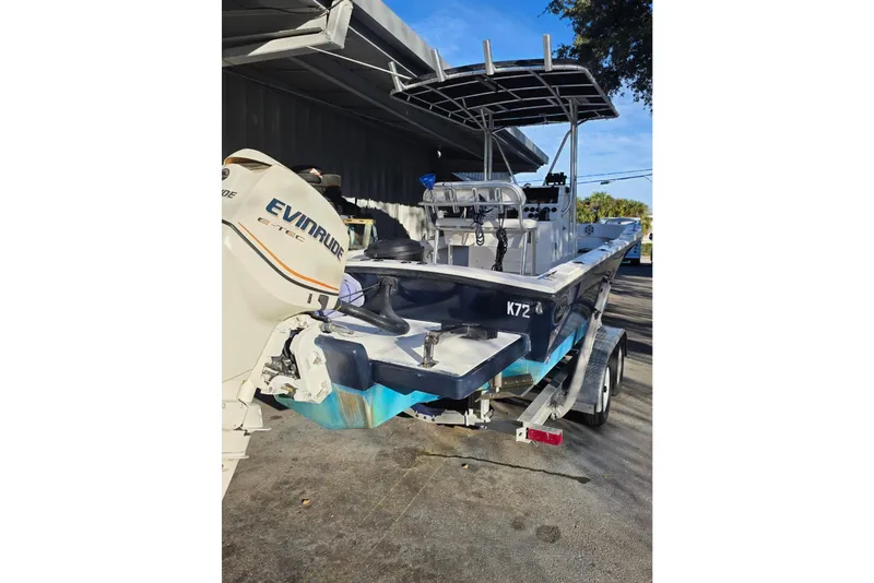 Slide: The Image of 2005 Dusky 203 boat with Evinrude engine on trailer, parked outdoors. - 15