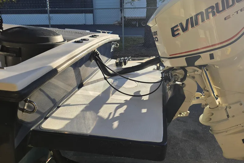 Slide: The Image of Dusky 203 boat with Evinrude motor, 2005 model, in a sunny outdoor setting. - 16