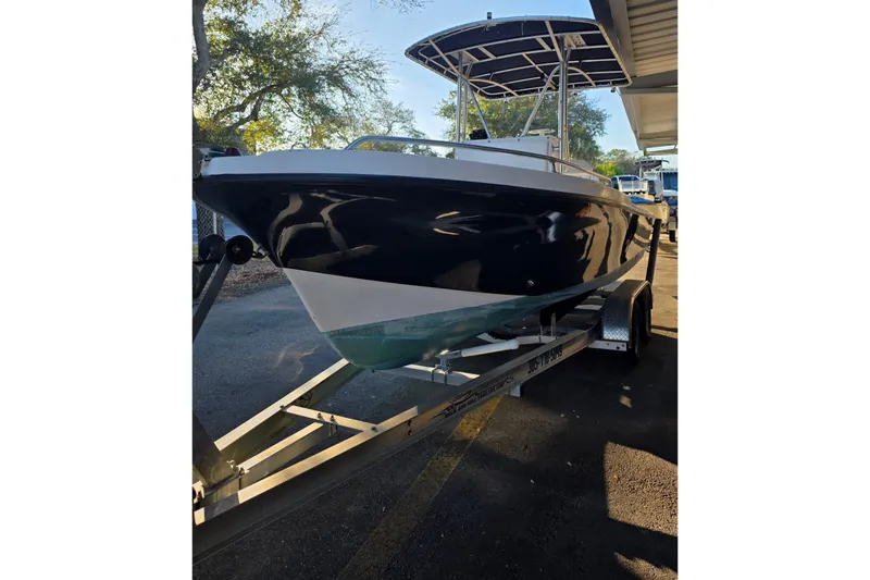 Slide: The Image of 2005 Dusky 203 boat on trailer, parked outdoors under partial shade. - 2