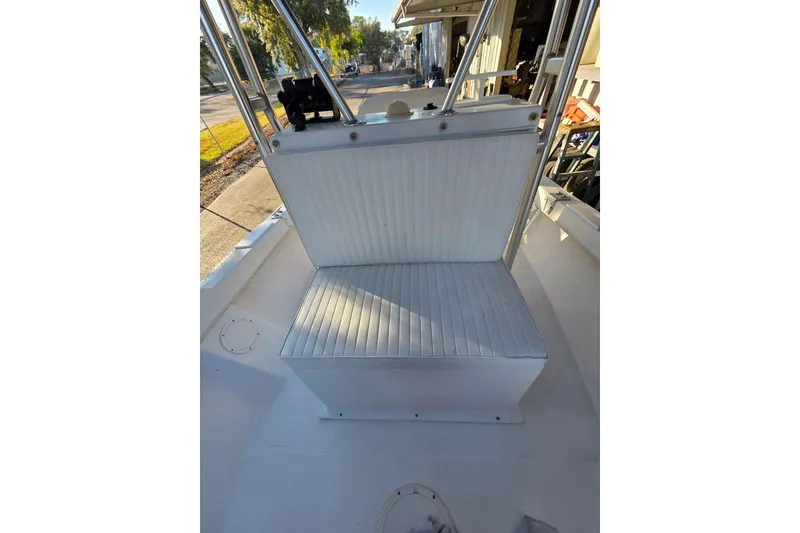 Slide: The Image of 2005 Dusky 203 boat interior with white cushioned seating and metal frame. - 9