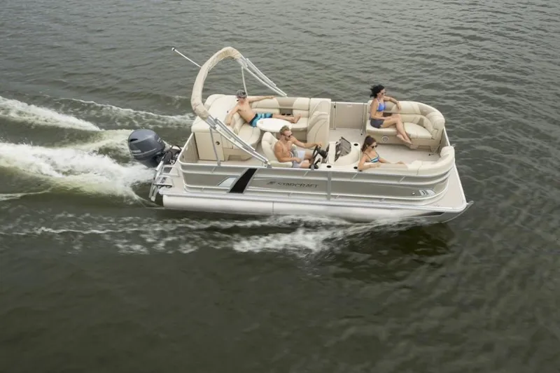 Slide: The Image of 2023 Starcraft EX 24 pontoon boat cruising on a lake with passengers. - 4