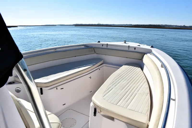 Slide: The Image of 2004 Grady-White Release 283 boat interior with cushioned seating on calm water. - 17