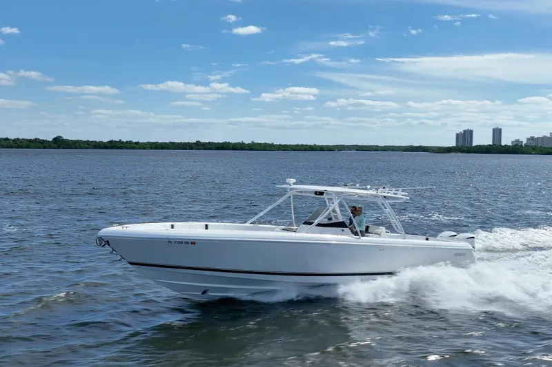Slide: The Image of 2011 Intrepid 400 Center Console boat cruising on a sunny day, with city skyline in background. - 15