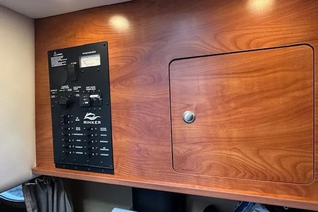 Slide: The Image of 2014 Rinker 260 Express Cruiser control panel with wooden cabinetry. - 16