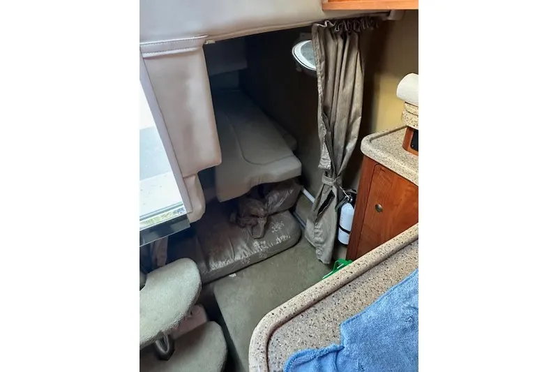 Slide: The Image of 2014 Rinker 260 Express Cruiser cabin interior with bed and storage area. - 19