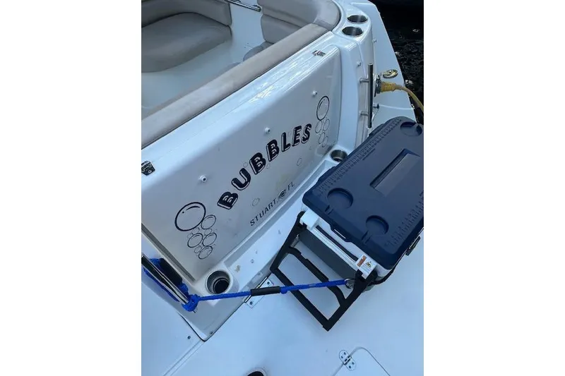 Slide: The Image of 2014 Rinker 260 Express Cruiser boat named "Bubbles" with cooler and seating area. - 20