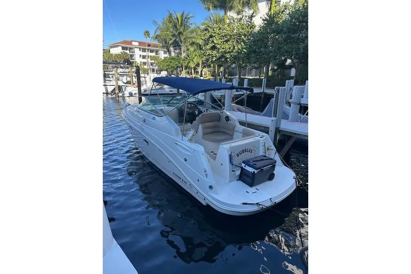 Slide: The Image of 2014 Rinker 260 Express Cruiser docked in a marina with blue canopy. - 23