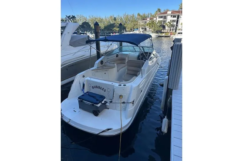 Slide: The Image of 2014 Rinker 260 Express Cruiser docked with blue canopy in marina. - 3