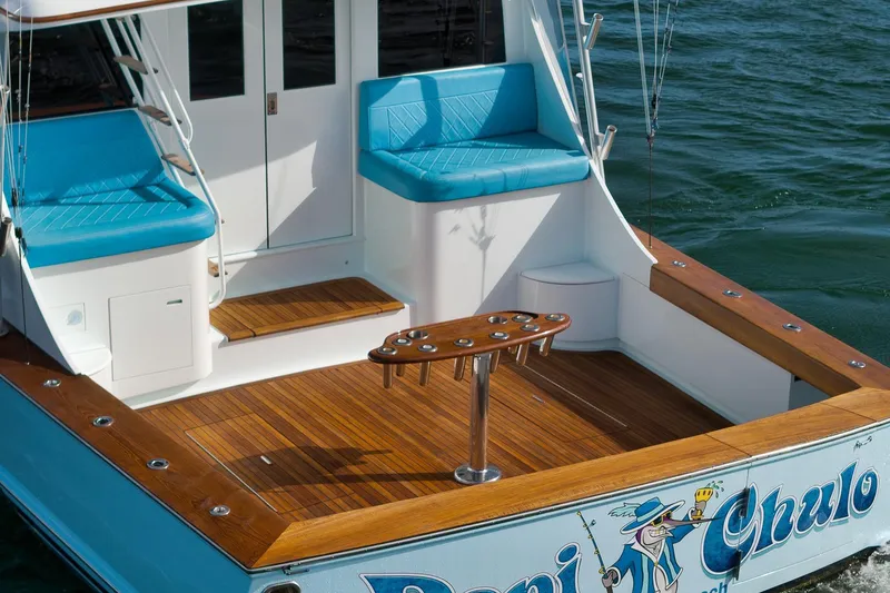 Slide: The Image of 1997 Garlington 61 boat with teak deck, blue seating, and fishing rod holders. - 10