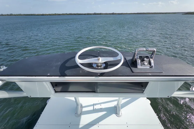 Slide: The Image of Helm of 1997 Garlington 61 boat with steering wheel and controls, overlooking water. - 12