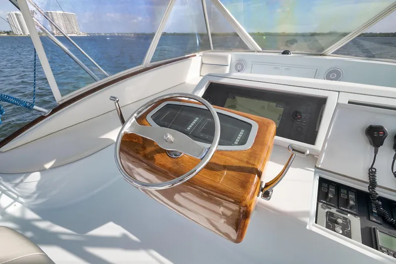 Slide: The Image of 1997 Garlington 61 yacht helm with wooden steering wheel and navigation controls. - 18