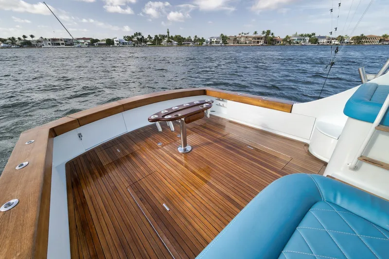 Slide: The Image of 1997 Garlington 61 yacht deck with wooden flooring and blue seating, overlooking calm waters. - 26