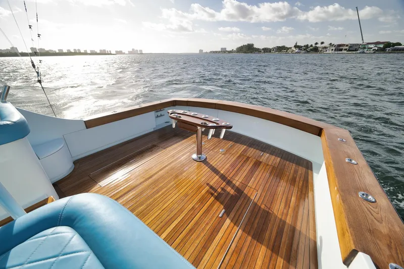 Slide: The Image of 1997 Garlington 61 yacht deck with wooden flooring, overlooking a scenic water view. - 27