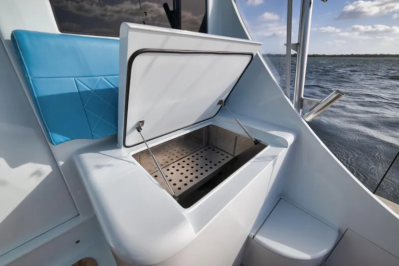 Slide: The Image of Open storage compartment on 1997 Garlington 61 yacht, featuring blue seating and ocean view. - 33