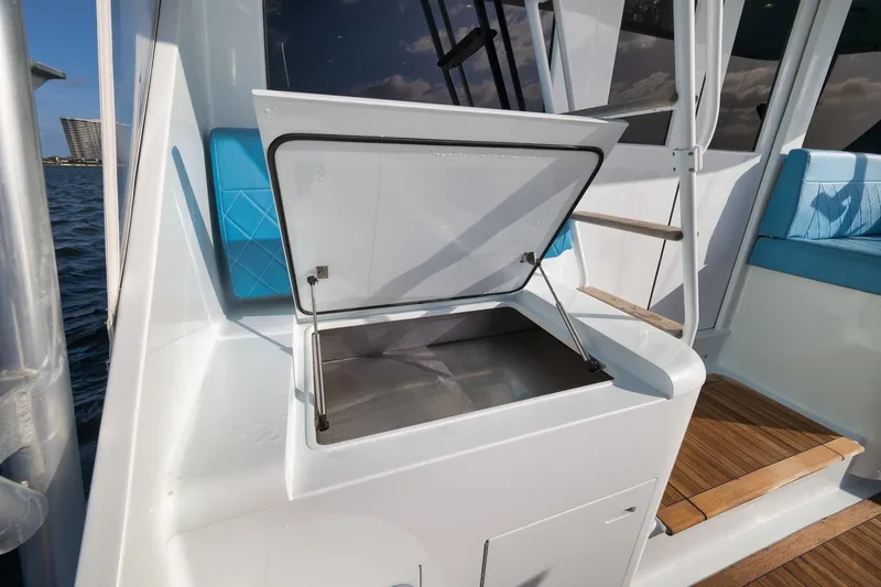 Slide: The Image of Open storage compartment on 1997 Garlington 61 boat deck with blue seating. - 36