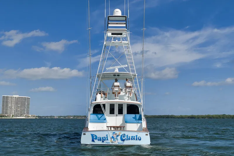 Slide: The Image of Garlington 61 yacht from 1997 on open water, clear sky, and distant buildings. - 4