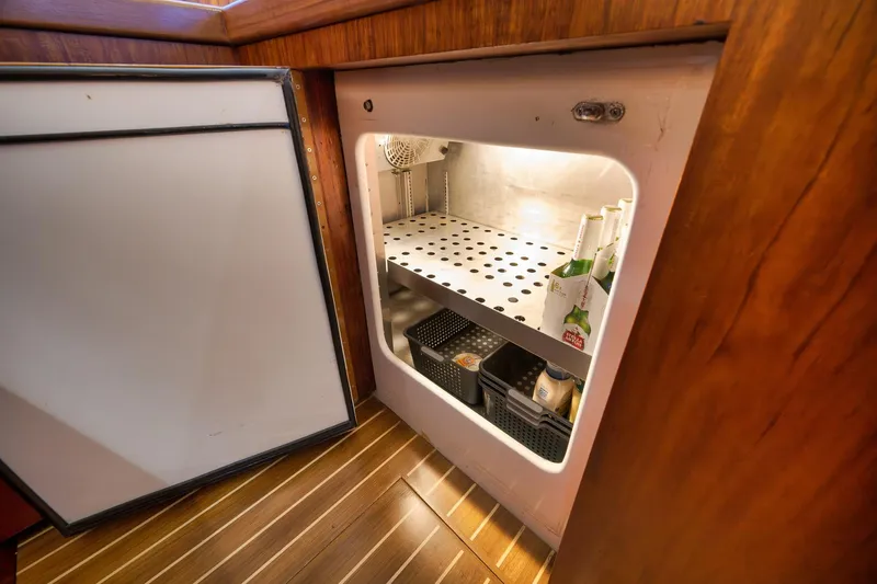 Slide: The Image of Open refrigerator in 1997 Garlington 61 yacht, showcasing organized interior storage. - 48