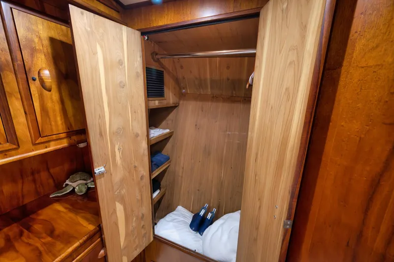 Slide: The Image of Wooden closet interior on a 1997 Garlington 61 yacht, featuring shelves and hanging space. - 60