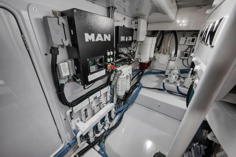 Slide: The Image of Engine room of 1997 Garlington 61 yacht, featuring MAN engine components and wiring. - 64