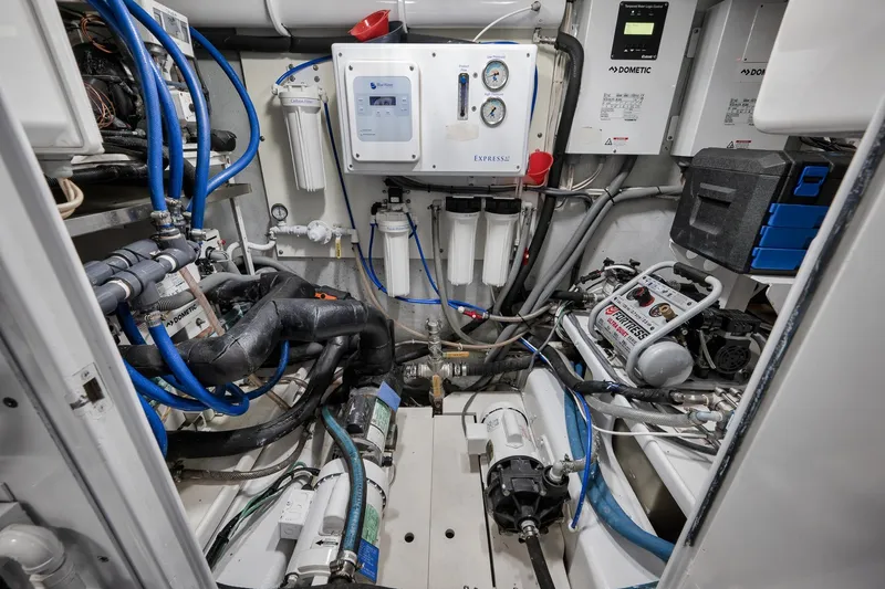 Slide: The Image of Engine room of a 1997 Garlington 61 boat, featuring complex machinery and piping. - 73