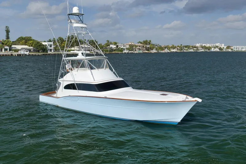 Slide: The Image of 1997 Garlington 61 yacht on calm water, featuring sleek design and spacious deck. - 80