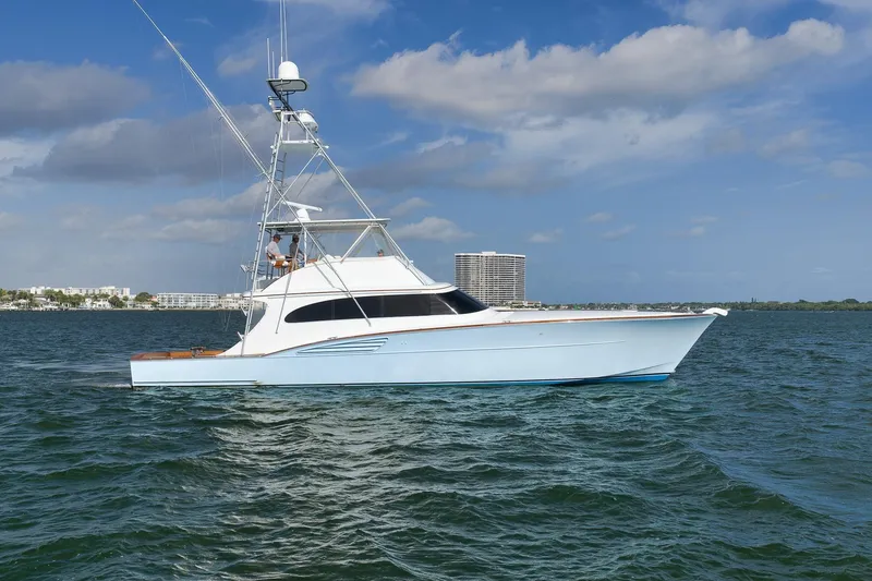 Slide: The Image of 1997 Garlington 61 yacht cruising on open water under a clear blue sky. - 81