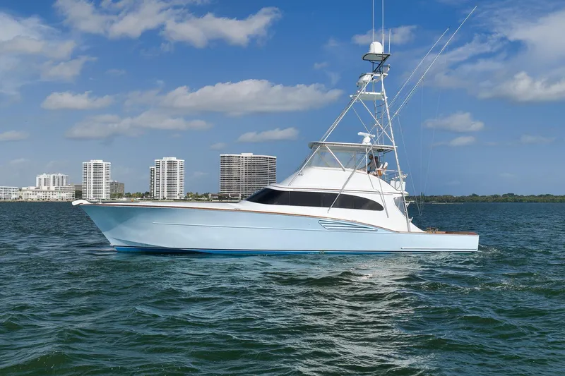 Slide: The Image of A 1997 Garlington 61 yacht cruising on a sunny day with city skyline backdrop. - 85