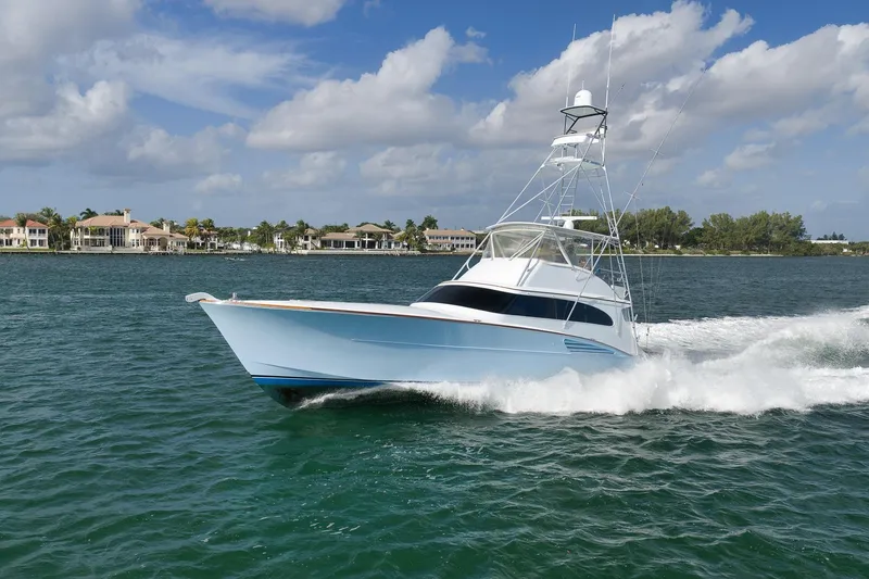 Slide: The Image of 1997 Garlington 61 yacht cruising on a sunny day near luxury waterfront homes. - 90