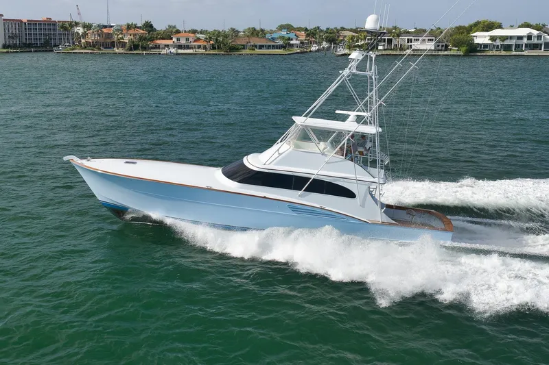 Slide: The Image of 1997 Garlington 61 yacht cruising on water near coastal homes. - 91