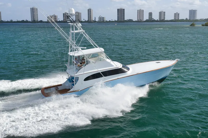 Slide: The Image of 1997 Garlington 61 yacht cruising on open water with city skyline in background. - 93