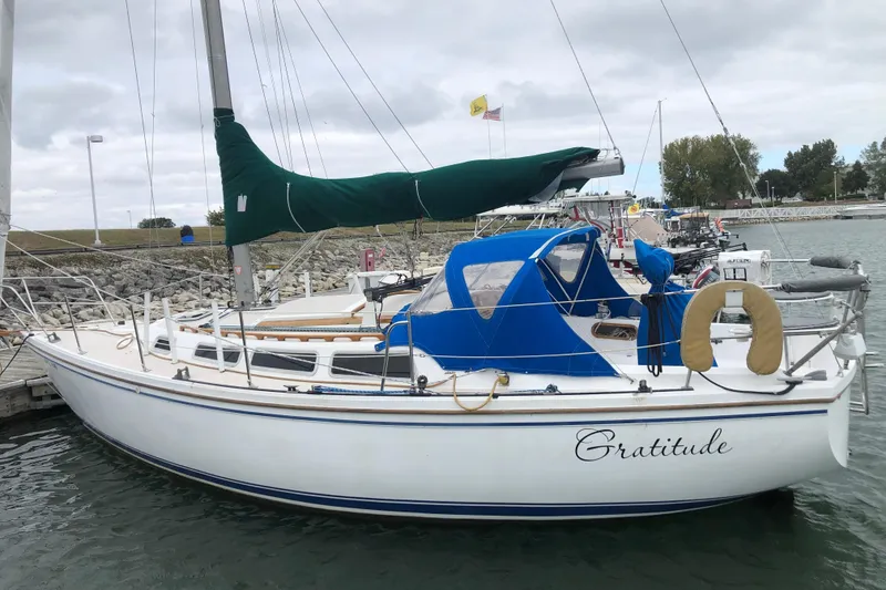 The Image of 1986 Catalina 30 MkII sailboat docked, featuring blue and green covers, named "Gratitude." - 1