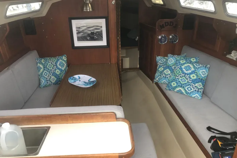 Slide: The Image of Interior of 1986 Catalina 30 MkII sailboat with cozy seating and decorative pillows. - 4