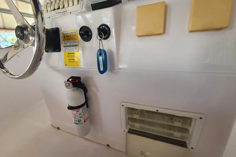 Slide: The Image of Console of 2002 Pro-Line 22 Sport boat with steering wheel and fire extinguisher. - 13