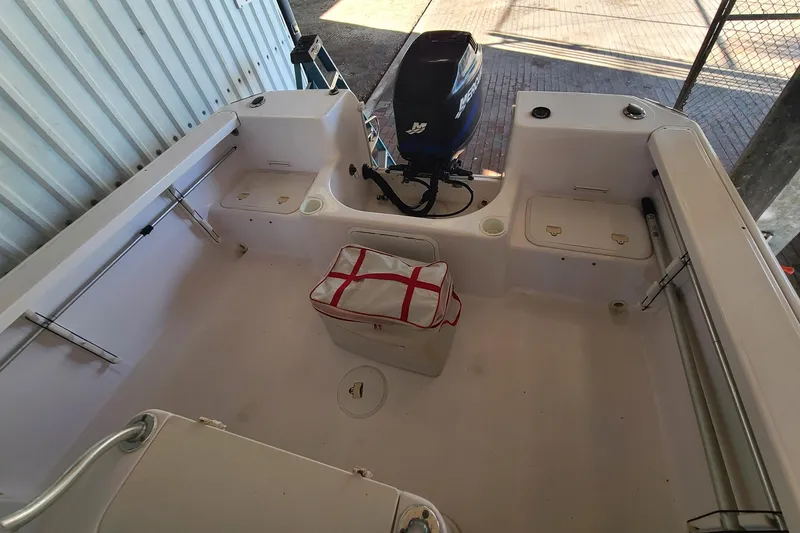 Slide: The Image of 2002 Pro-Line 22 Sport boat interior with storage compartments and outboard motor. - 16