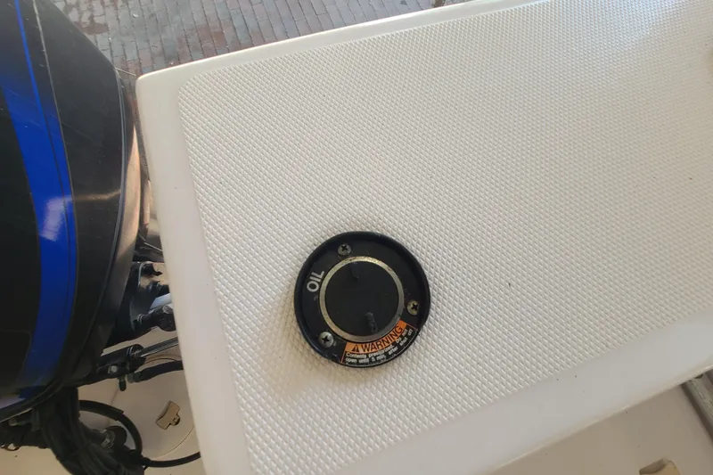 Slide: The Image of Oil cap on 2002 Pro-Line 22 Sport boat deck, textured surface, engine visible. - 18