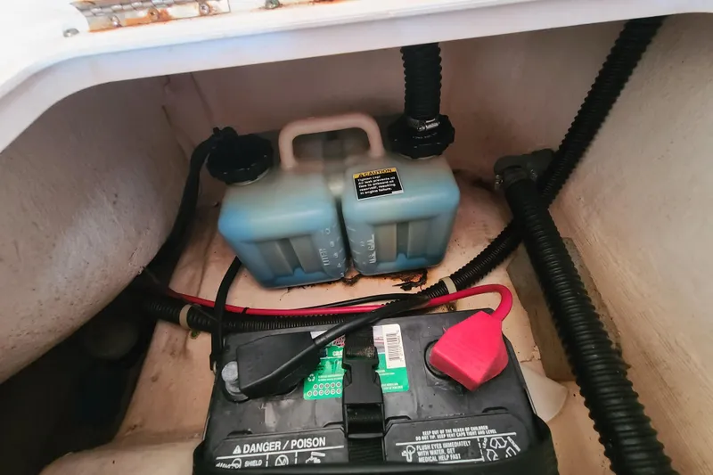 Slide: The Image of Battery and fluid containers in a 2002 Pro-Line 22 Sport boat compartment. - 19
